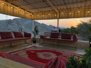 eine Terrasse mit 2 Sofas und einem Teppich in der Unterkunft Algor Farm in Qūr