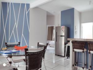 a kitchen with a table and a refrigerator at Apartamento completo com 3 quartos in Porto Seguro