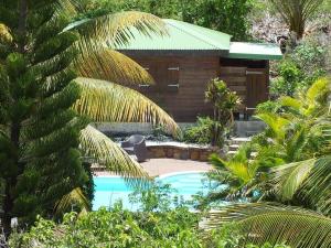 un resort con piscina e un edificio di RARE : Bungalow bois avec piscine privée , Gîte ti plaisir a Le Moule