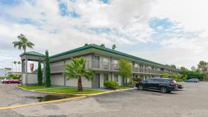 un hôtel avec une voiture garée sur un parking dans l'établissement Heated Pool, Huge TV, Waterfront Tiki Bar & Grill, Close to Beaches, à Sarasota