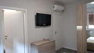 Habitación con TV de pantalla plana en la pared en casa serrati(locanda la cascina)camera con bagno privato ma cucina in comune, en San Giuliano Milanese