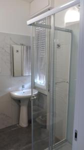 y baño blanco con lavabo y ducha. en casa serrati(locanda la cascina)camera con bagno privato ma cucina in comune, en San Giuliano Milanese