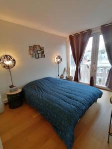 een slaapkamer met een blauw bed en een raam bij Ô Pied Marin in Le Tréport +28 foto's