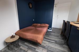 1 dormitorio con 1 cama en una pared azul en NUIT BY LIGHT - Dormir Comme A La Maison en Châteaubriant