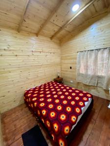 een slaapkamer met een groot bed in een houten kamer bij Cabaña el kiosko in Zipaquirá