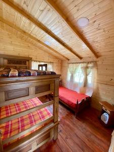 een slaapkamer met 2 bedden in een blokhut bij Cabaña el kiosko in Zipaquirá