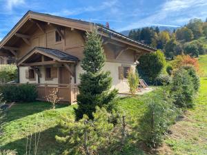 a house with a pine tree in front of it at Chalet Megeve, idéal familles proche ski et centre village in Megève