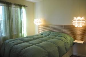 a bedroom with a large bed and two lights at Elementos del diablo in Punta Del Diablo