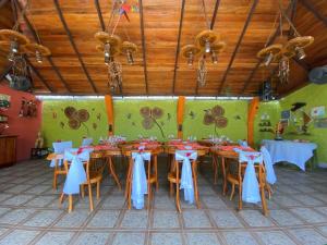 a dining room with tables and chairs with blue bows at Hotel Puerto Gaviota in Tonsupa