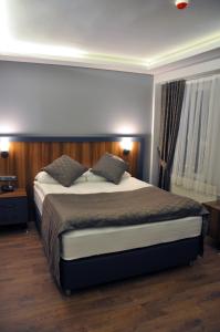 a bedroom with a large bed with two pillows at SAKALİFE APART Otel in Erzurum +37 photos