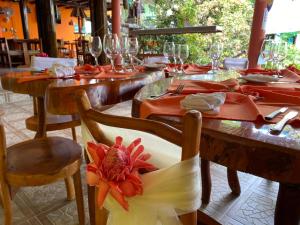 a restaurant with wooden tables and chairs with a flower on the seat at Hotel Puerto Gaviota in Tonsupa