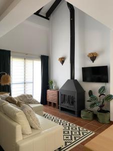 a living room with a white couch and a fireplace at El Capricho in El Ronquillo