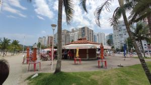 a gazebo in a park with palm trees and buildings at Cobertura Com Vista Para a Praia in São Vicente