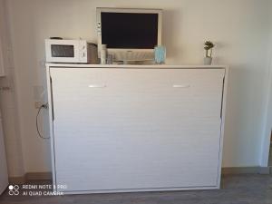 a white cabinet with a microwave on top of it at ESTUDIO SOLYPLAYARELAX in Fuengirola