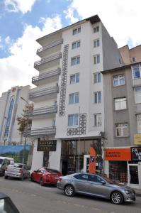 a large white building with cars parked in front of it at SAKA LİFE OTEL in Erzurum