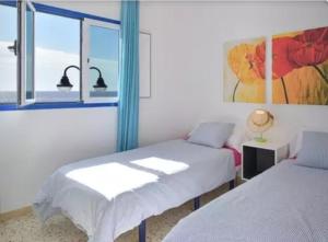 a bedroom with two beds and a window at Aguaviva in Punta Mujeres