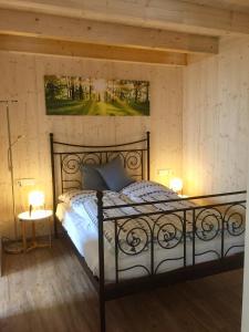 een slaapkamer met een zwart bed en 2 lampen bij Emma in Burladingen