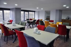 a dining room with tables and colorful chairs at SAKALİFE APART Otel in Erzurum