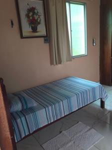 a bed sitting in a room with a window at Apartamento Suíte em Soure. in Soure