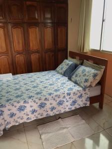 a bedroom with a bed with a blue and white comforter at Apartamento Suíte em Soure. in Soure