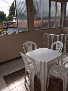 a white table and chairs in a room with windows at Apartamento Suíte em Soure. in Soure