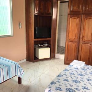 a room with a tv and a bed and a cabinet at Apartamento Suíte em Soure. in Soure