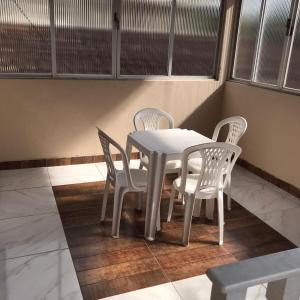 Biały stół i krzesła w pokoju w obiekcie Apartamento Suíte em Soure. w mieście Soure