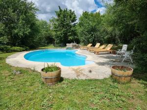 una piscina con mesa de picnic y sillas en un patio en The old farmhouse of Goth en Sérignac