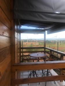 een tafel op het balkon van een hut bij Casa de Madeira in Delfinópolis