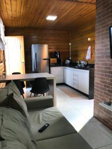 a kitchen with a couch and a table in a room at Casa de Madeira in Delfinópolis