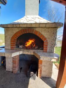 a brick oven with a fire in it at Vikendica Vlahić, Goranci in Mostar