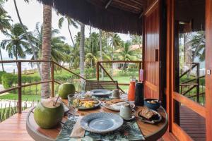 uma mesa com pratos de comida num alpendre em Carneiros Paradiso em Praia dos Carneiros