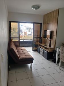 a living room with a couch and a window at Apt 2 quartos acomoda 10 pessoas a 450 metros da praia de Jatiúca in Maceió