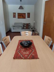 a dining room table with a red rug on it at Aires Andinos in Mendoza