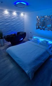 um quarto com uma cama grande e luzes azuis em Apartment Wave -Luxury massage chair-Infrared Sauna, Parking with video surveillance, Entry with PIN 0 - 24h, FREE CANCELLATION UNTIL 2 PM ON THE LAST DAY OF CHECK IN em Slavonski Brod