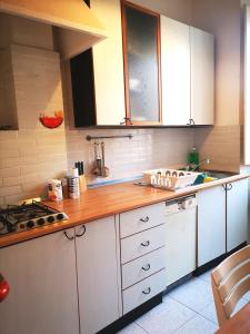 a kitchen with white cabinets and a wooden counter top at Al Curvone Beach in Lido di Ostia