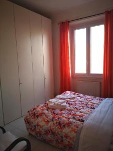 a bedroom with a bed with red curtains and a window at Al Curvone Beach in Lido di Ostia