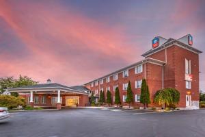 a large red brick building with a parking lot at SureStay Plus Hotel by Best Western Kincardine in Kincardine