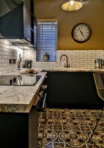 a kitchen with a sink and a clock on the wall at Lletty by Orenda-Luxe in Llandudno