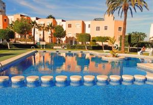 duży basen z błękitną wodą i budynkami w obiekcie Holiday House Torre Mata w mieście Torrevieja