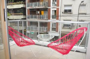 two red chairs sitting on top of a balcony at Moderno departamento en el Corazon de Recoleta in Buenos Aires