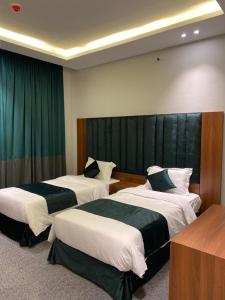 a hotel room with two beds in a room at اضواء السلام للشقق المخدومة in Medina