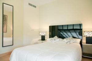 聖塞巴斯蒂安德洛斯雷耶斯的住宿－Charming San Sebastián de los Reyes，白色的卧室配有一张白色的大床和镜子