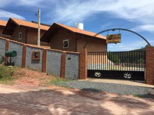 a house with a gate and a fence at Pousada Recanto do Aeroporto in Monte Verde