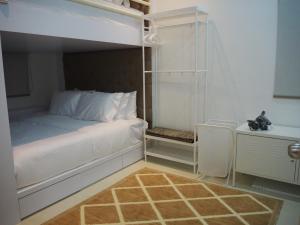 a bedroom with a white bed and a desk at Terengganu Guest House 2 in Marang