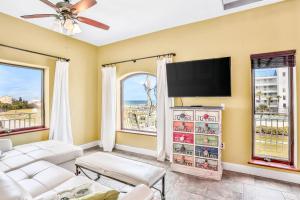 a living room with a flat screen tv and windows at Sea Turtle Manor in New Smyrna Beach