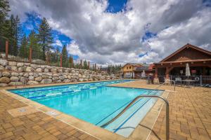 a swimming pool with a stone wall and a building at Truckee Living in Truckee