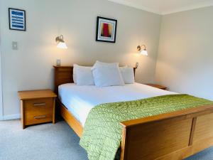 a bedroom with a large bed and two lamps at Ngati Ruanui Stratford Mountain House in Stratford