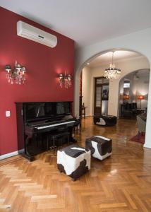 a living room with a piano and red walls at Magnolia Hotel Boutique in Buenos Aires