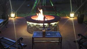 a fire pit with a table and a wine glass at Palast Haus Pousada in Gramado